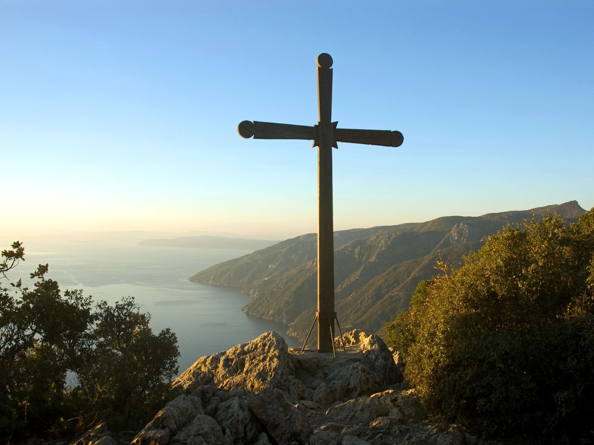 Cruce de lemn pe un vârf stâncos din Athos, la apus