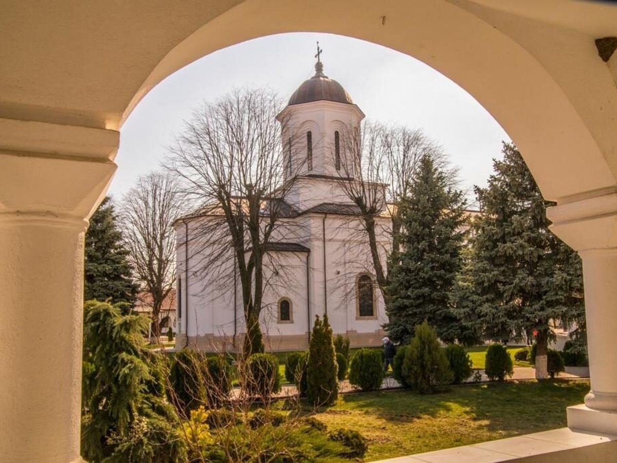 Biserica Mănăstirii Ghighiu văzută printr-o arcadă