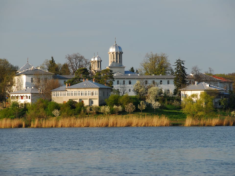 Mănăstire pe malul unui lac, primăvara